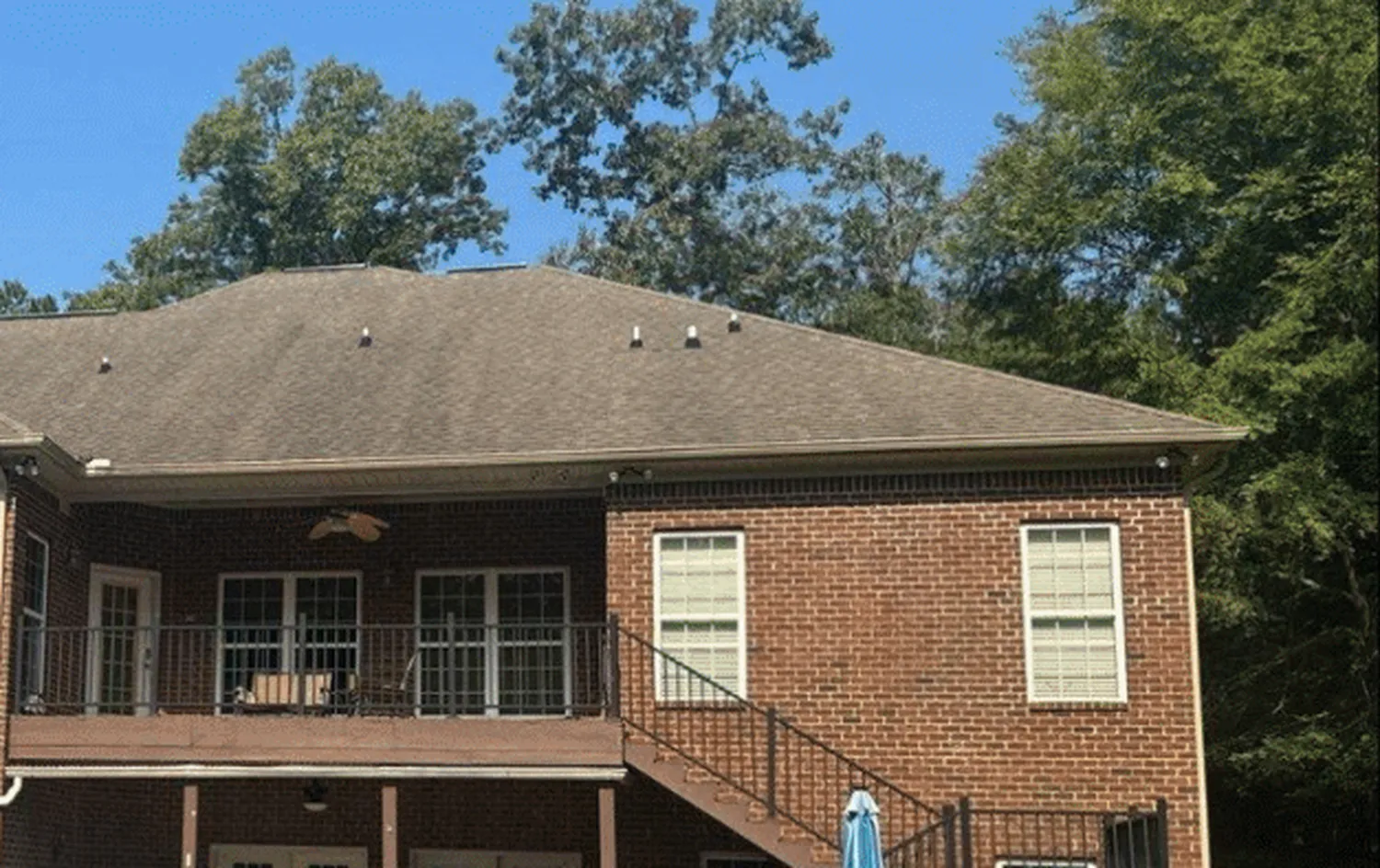 Before treatment — two-story brick home, rear elevation
